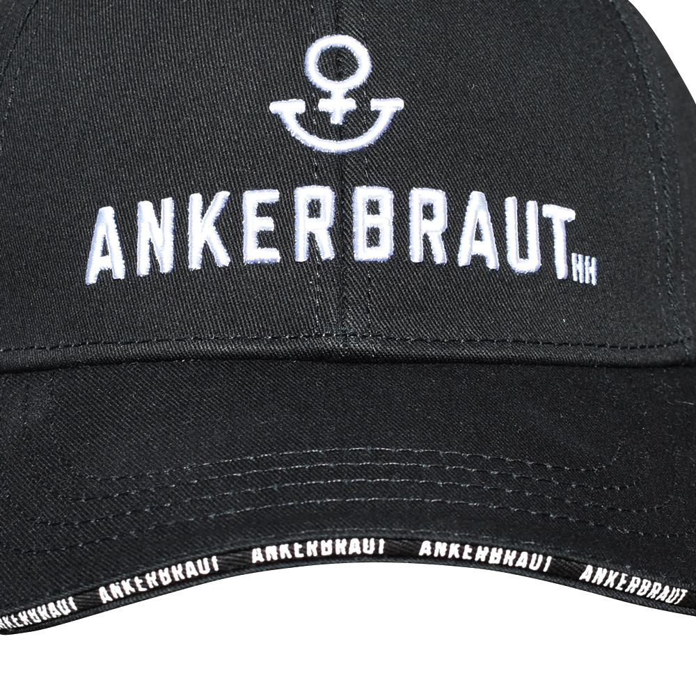 Weibliches Model mit ANKERBRAUT Cap in Schwarz