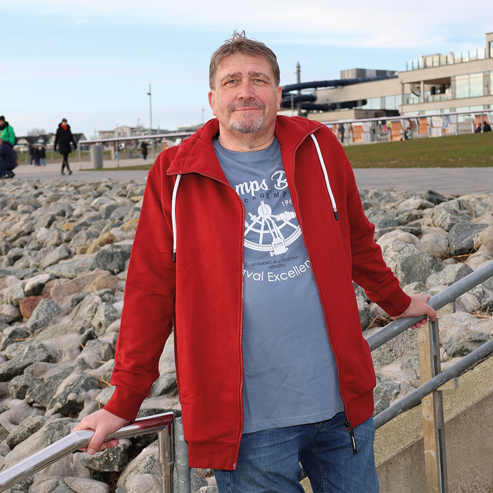 Männliches Model mit CAMPS BAY Sweatjacke in Sun Dried Tomato