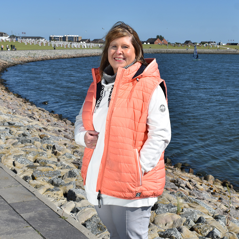 Weibliches Model mit CAMPS BAY Weste in Fusion Coral