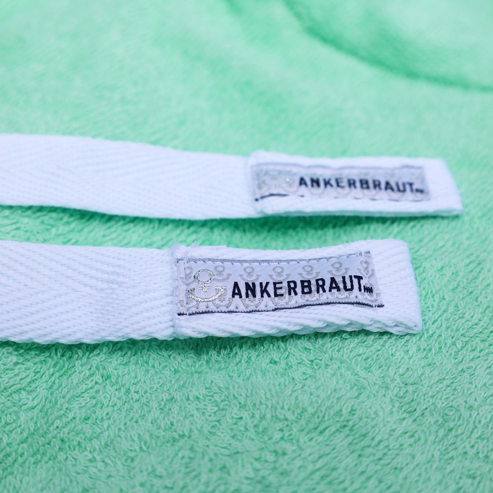 Weibliches Model mit ANKERBRAUT Beach-Poncho in Green