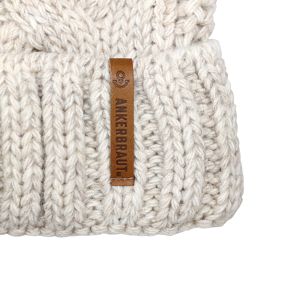 Weibliches Model mit ANKERBRAUT Mütze in Beige