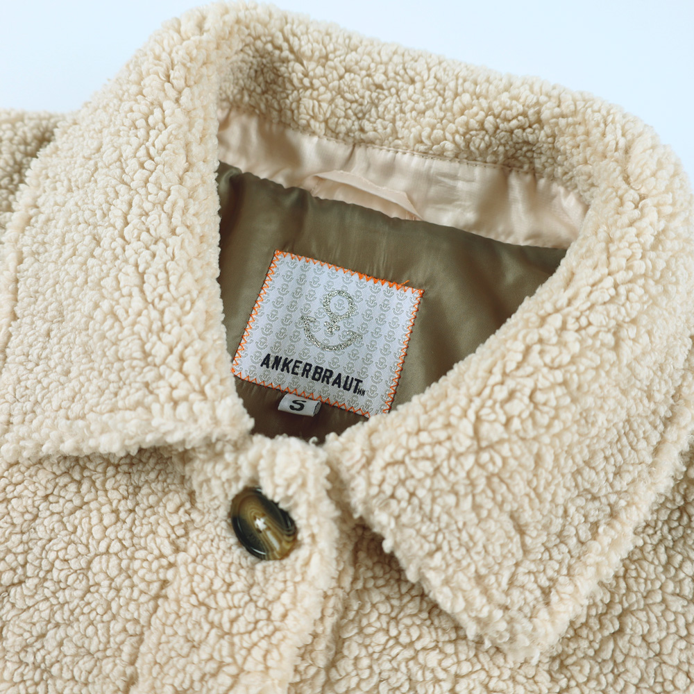 Weibliches Model mit ANKERBRAUT Teddy-Mantel in Offwhite