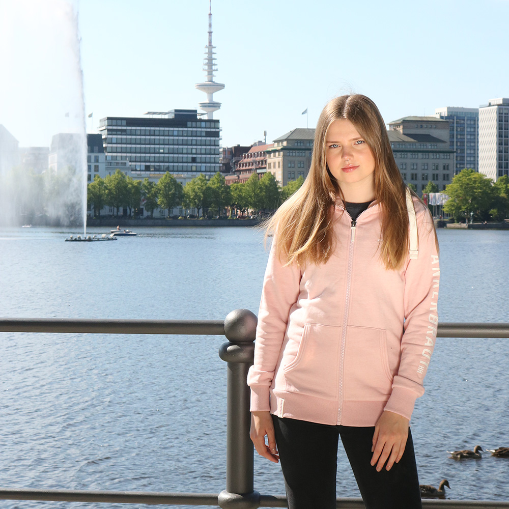 Weibliches Model mit ANKERBRAUT Sweatjacke in Rosa Melange