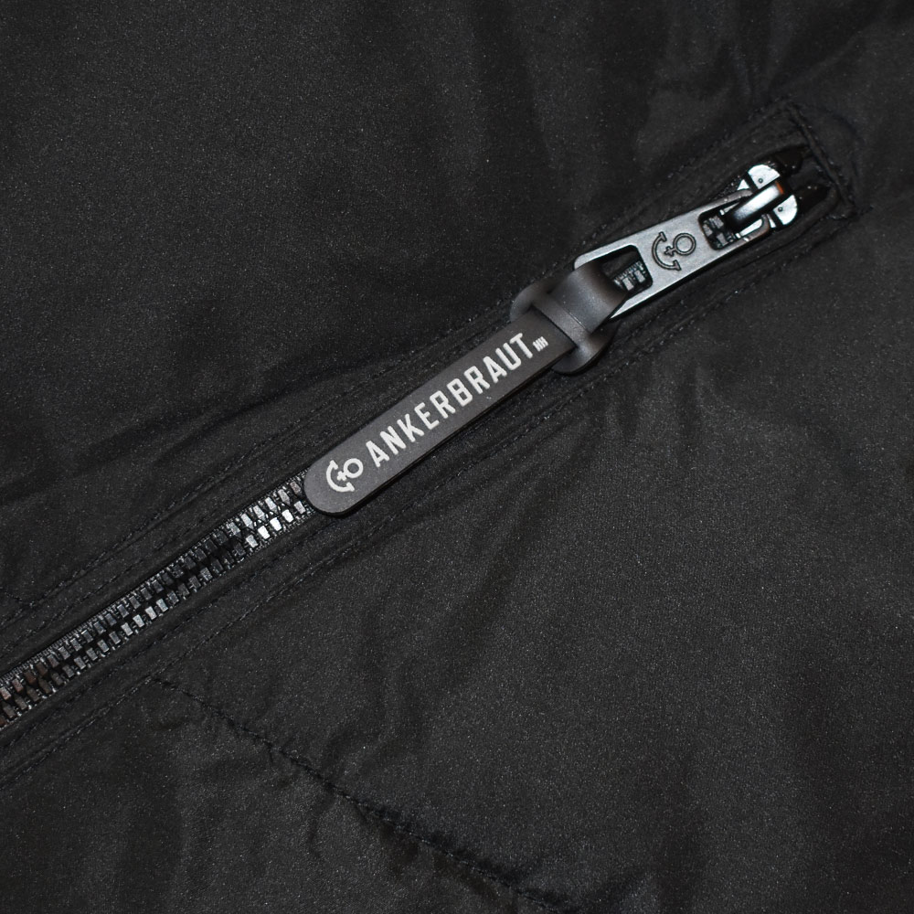 Weibliches Model mit ANKERBRAUT Mantel in Schwarz