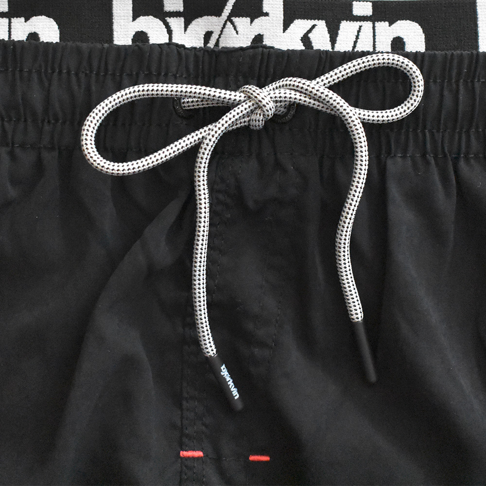Männliches Model mit Björkvin Badeshorts in Schwarz
