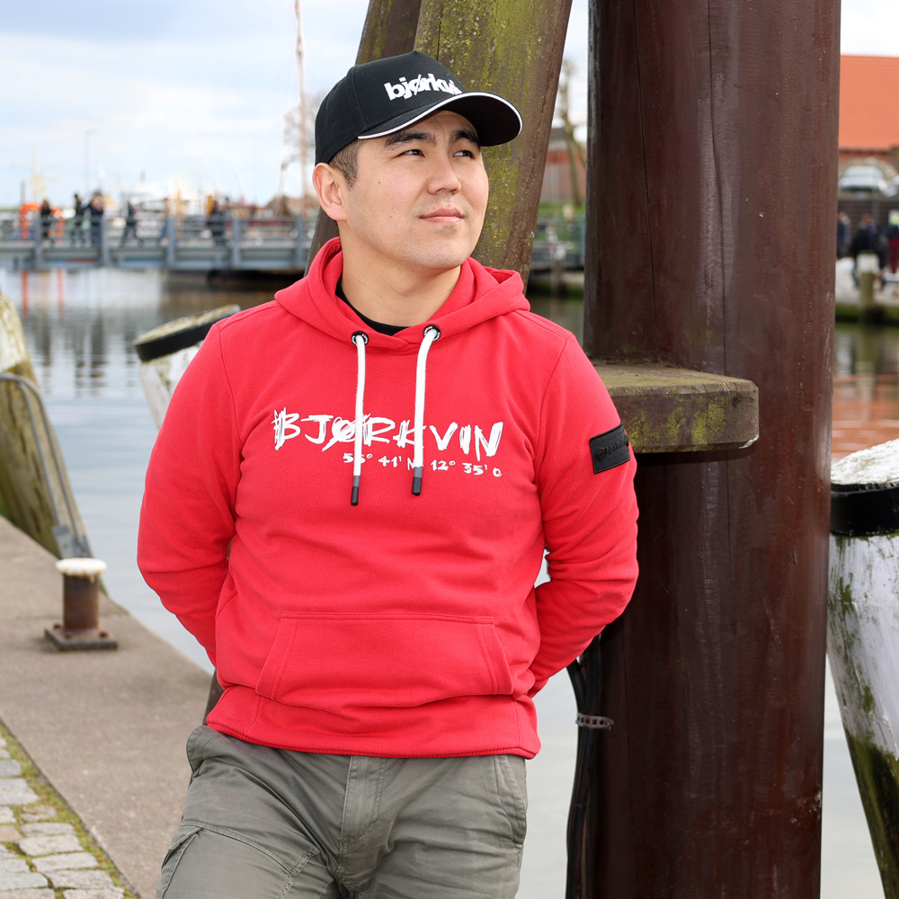 Männliches Model mit Björkvin Hoodie in Rot