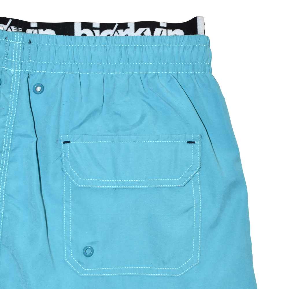 Männliches Model mit Björkvin Badeshorts in Petrol