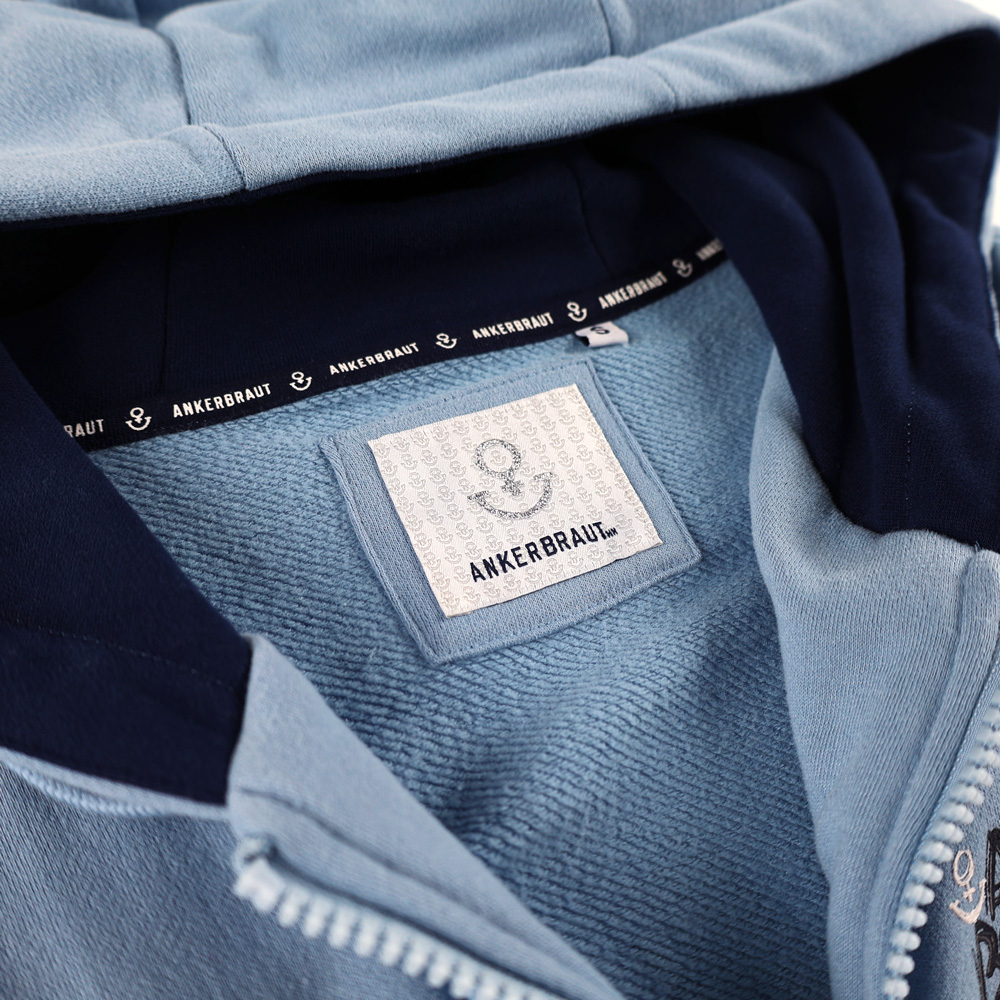Weibliches Model mit ANKERBRAUT Sweatjacke in Forever Blue