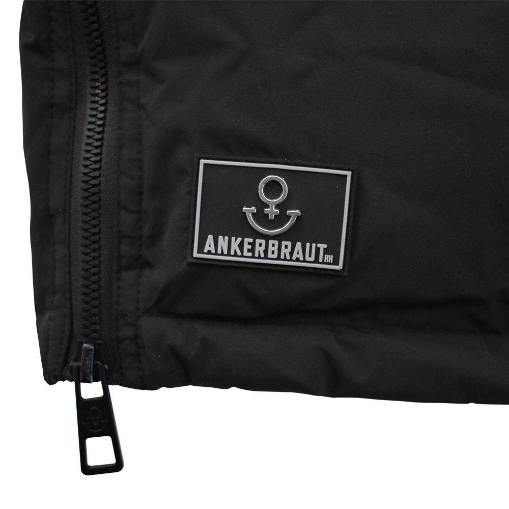 Weibliches Model mit ANKERBRAUT Mantel in Schwarz