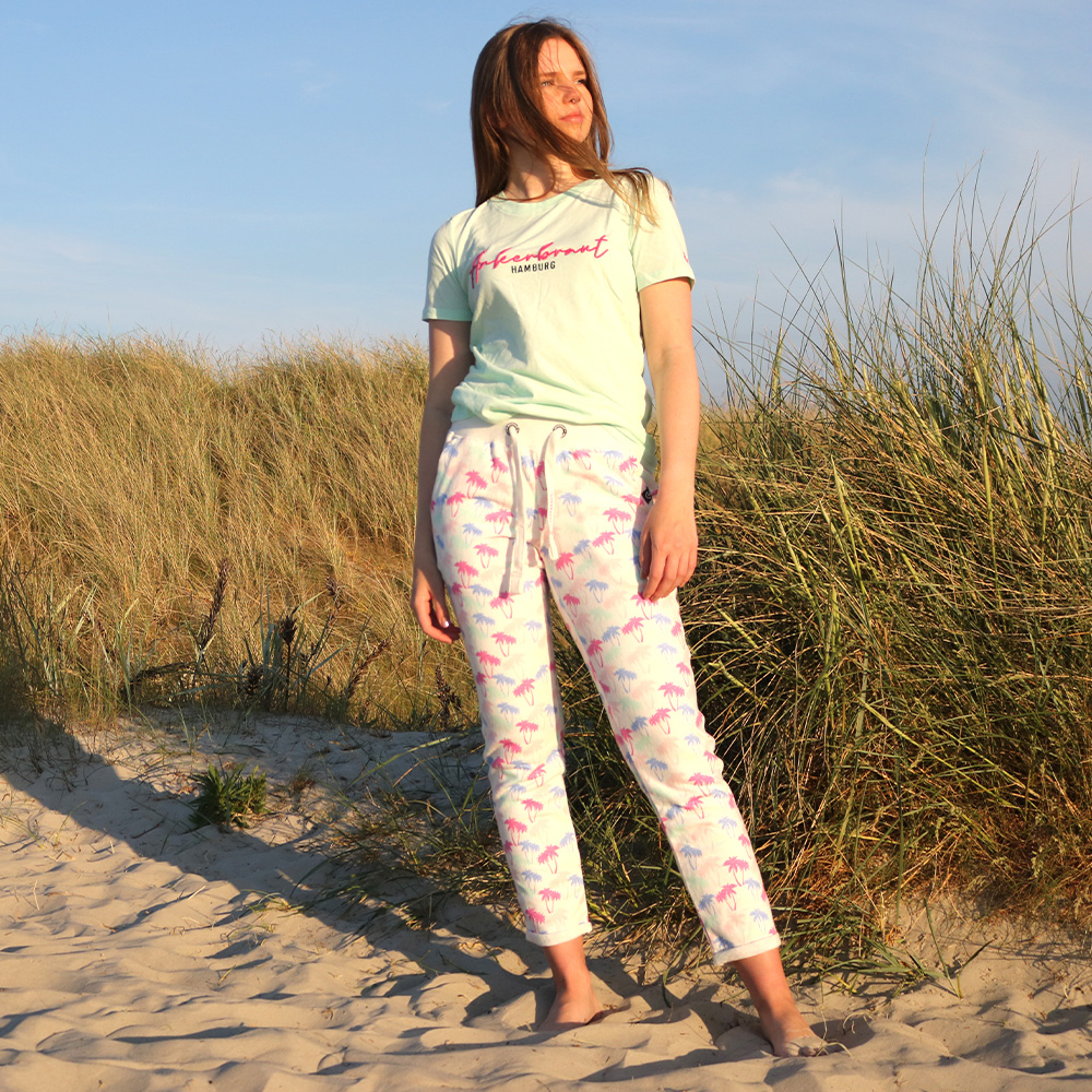 Weibliches Model mit ANKERBRAUT Sweathose in Offwhite Palmen