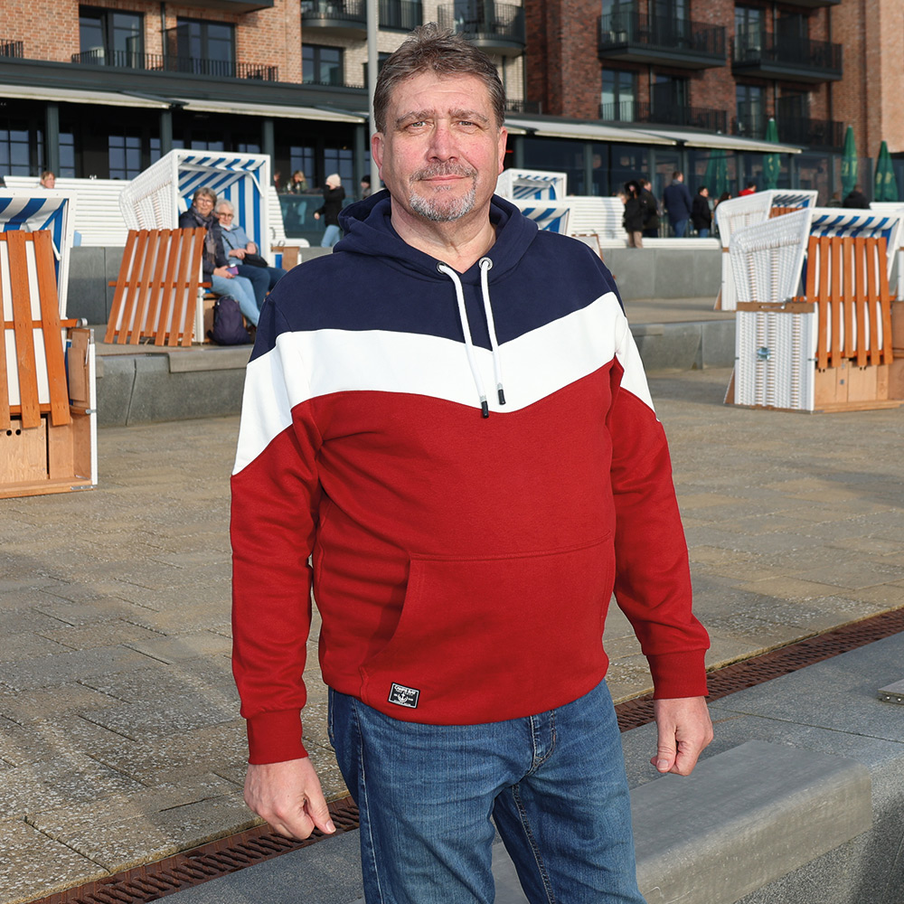 Männliches Model mit CAMPS BAY Hoodie in Sun Dried Tomato