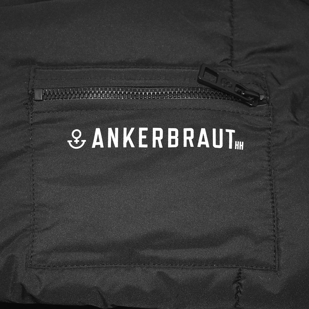 Weibliches Model mit ANKERBRAUT Mantel in Schwarz
